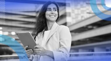 A woman holds a tablet with a confident look