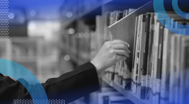A hand takes a book off a library shelf