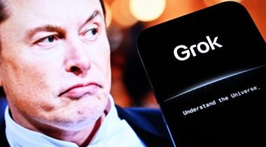 Elon Musk is pictured next to a smartphone displaying the Grok app.