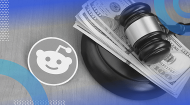 A Reddit logo next to a gavel atop a stack of $100 bills