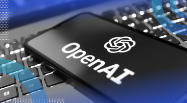 A smartphone with the OpenAI logo on top of a laptop keyboard