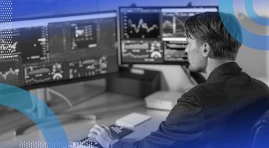 A white collar worker uses multiple screens to multitask