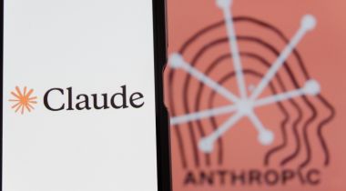 Image of smartphone screen with the Claude logo displayed, on top of a dark-orange background with the word "Anthropic" in black.