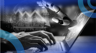 A robotic hand reaches out of a laptop screen as hands type on it with a downward economic trendline on top of it