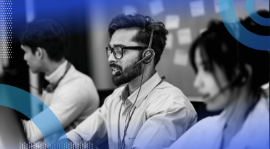 A software engineer in front of a kanban board speaks on a headset