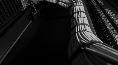 A collection of gray cables is connected, overlayed on top of a black background.