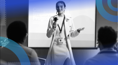 A woman in a business suit gives a presentation in front of a screen