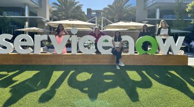 ServiceNow interns pose next to the sign outside.