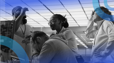 A group of employees argue around a computer