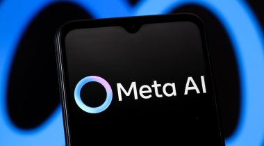 The Meta AI app logo displayed on a mobile phone, with the Meta logo in the background.