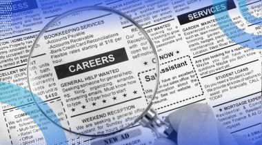 A magnifying glass over a newspaper classified ad