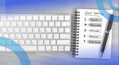 A notepad with a definition of "SMART goals" next to a keyboard