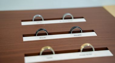 Three pairs of Oura Rings are lined up on a wood table.