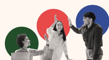 A photo of three employees high-fiving in front of colorful shapes to show the idea of working on a team that puts people first and has great employee engagement. 