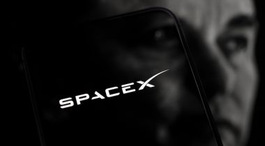 The SpaceX logo superpositioned over the face of CEO Elon Musk.