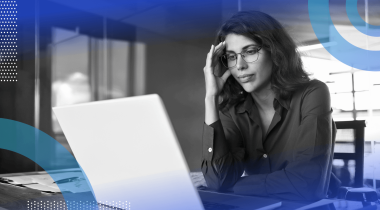 A woman looks at her laptop with frustration.
