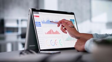 A hand uses a pen to point to a visualization on a big data analytics tool.