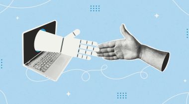 A human hand reaches out to a robotic hand coming out of a laptop screen.