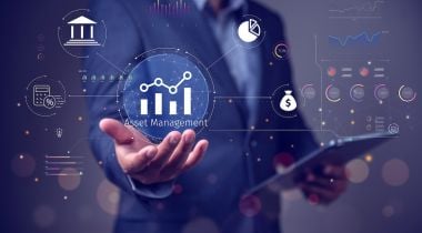 A man in a suit holds an analytics graphic in one hand and a tablet in the other.