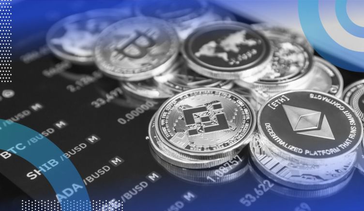A stack of crypto coins on top of a smartphone with a market reading on it