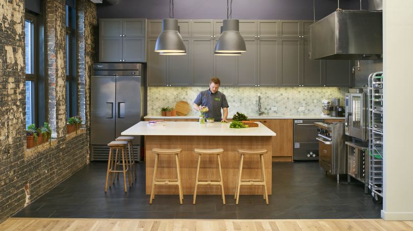 Man prepares a salad in the Farmer's Fridge kitchen