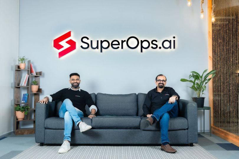 SuperOps co-founders pose together for a photo under the SuperOps logo sign.