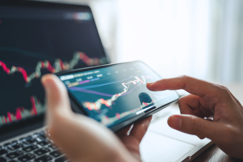 Woman is checking Bitcoin price chart on digital exchange on smartphone, cryptocurrency future price action prediction.