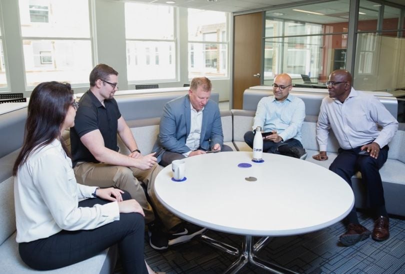 DFIN team chatting at a conference room