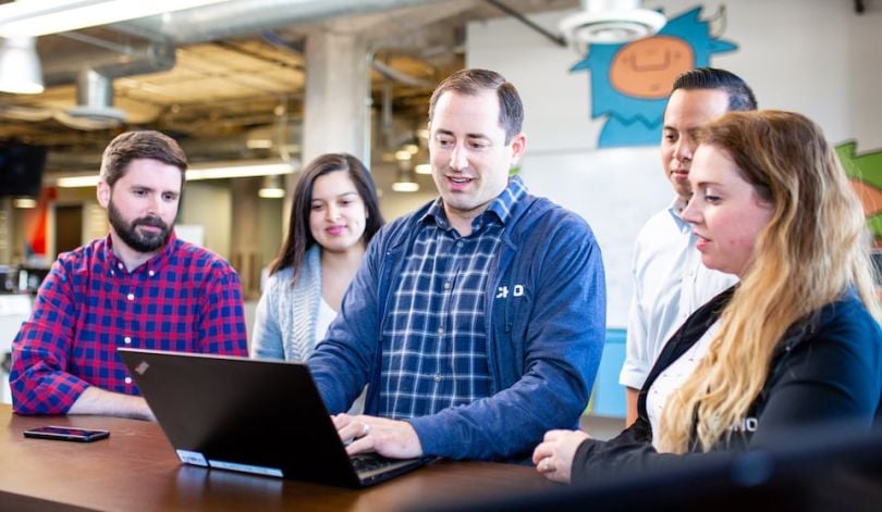 Echo Global Logistics staff working around a single laptop