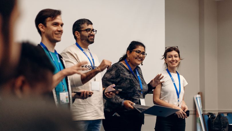 MaestroQA team members stand on a stage