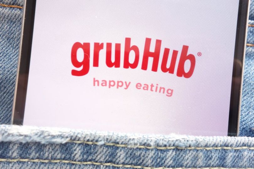 Grubhub logo on phone situated in pants pocket