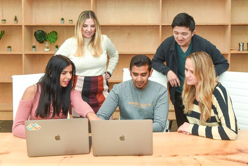 Lattice colleagues having a team huddle looking at laptops