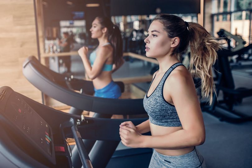 Two women running on treadmills