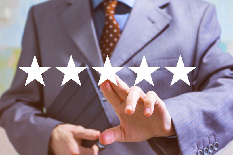 Man in suit marks 5 stars on board