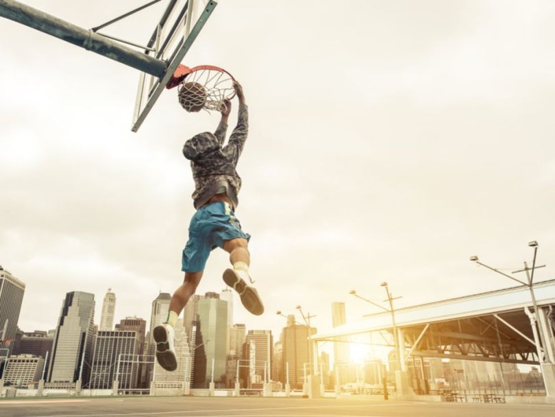 A young man dunking on a basketball hoop