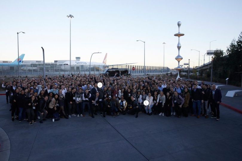 The TripActions team gathers for a company photo at an airport.