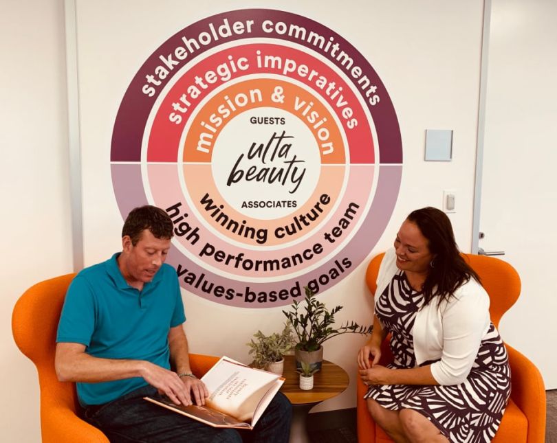 Two Ulta team members chatting and working 