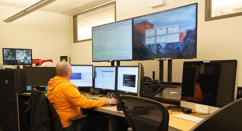 Vail Systems team member working at station with lots of monitors