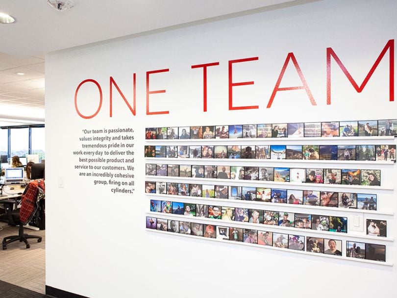 A large sign that reads "One Team" in AlertMedia's office