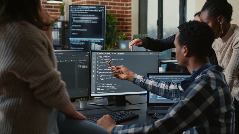 Several developers work on computer code.