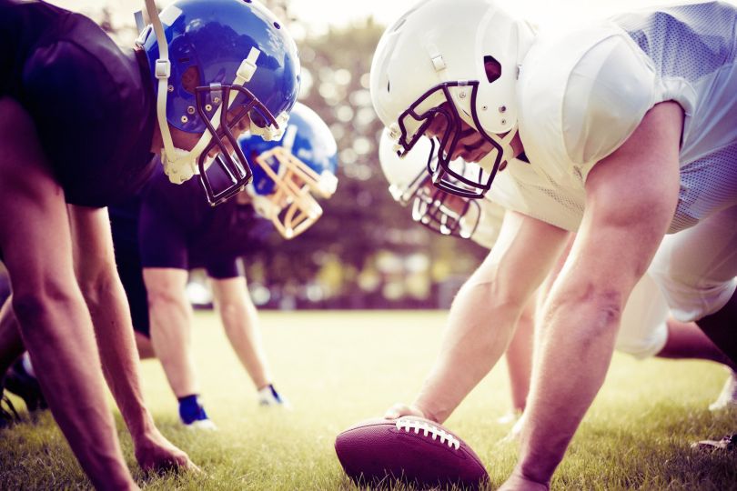 American football players prepare to start a game.