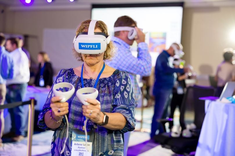 Wipfli team members using VR headsets and handsets at a summit