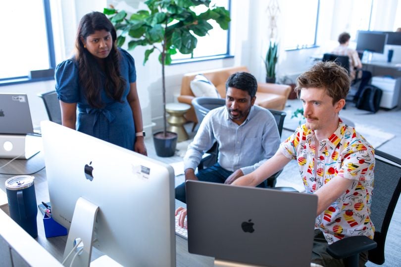 Three Built In team members looking at a screen and discussing