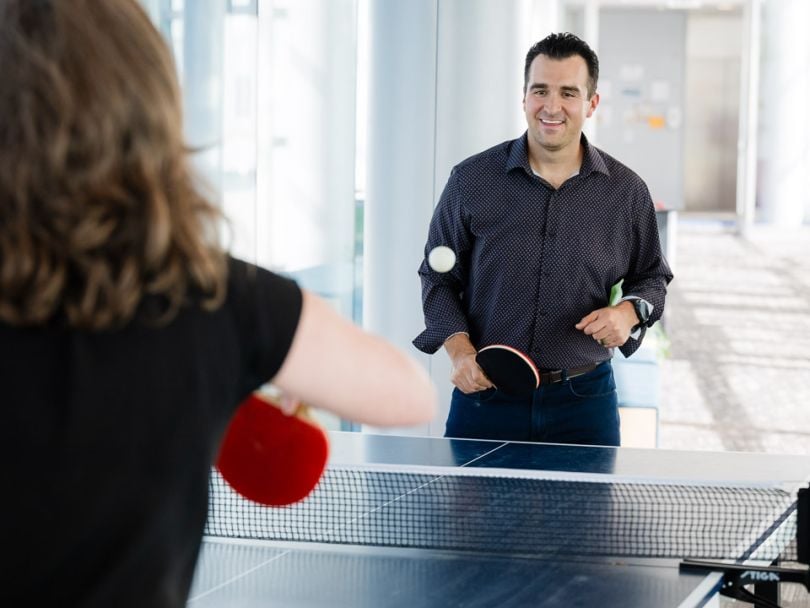 Eric DePinto plays a game of ping pong with a colleague