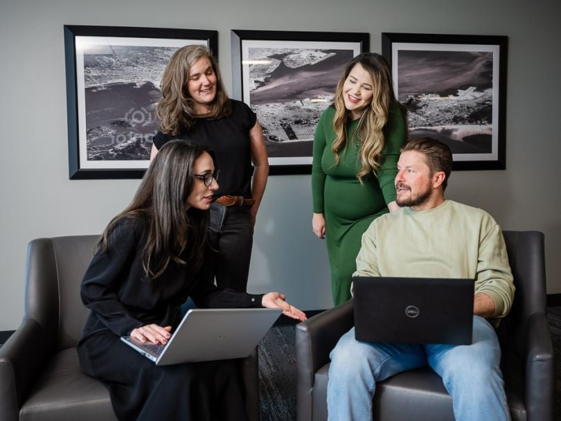 Four colleagues chat together while working in the Vantor office