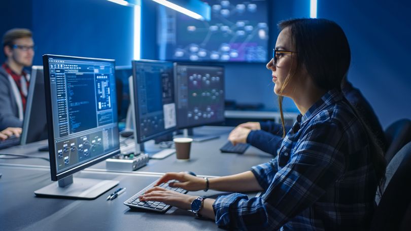 Female IT programer working on a desktop computer