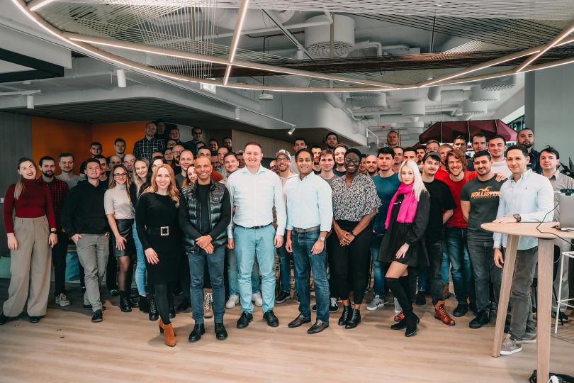 Group photo of GoHealth employees in the office, raising champagne glasses