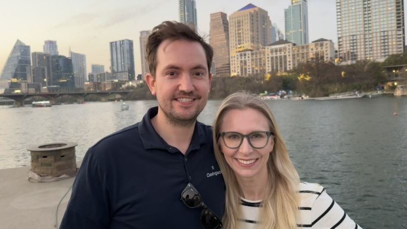 Andy and Abigail White, founders of Closinglock, standing in front of the Colorado River with the Austin skyline in the background.