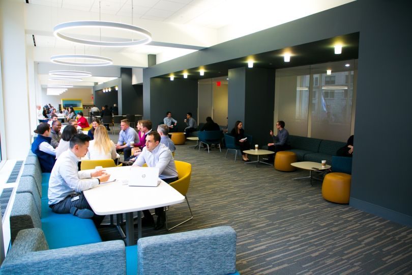 Photo of large room with people gathered around tables