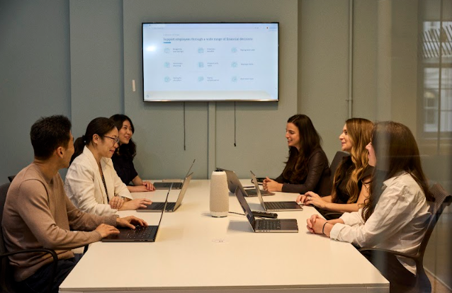 Addition Wealth employees share a discussion over a presentation in a conference room.